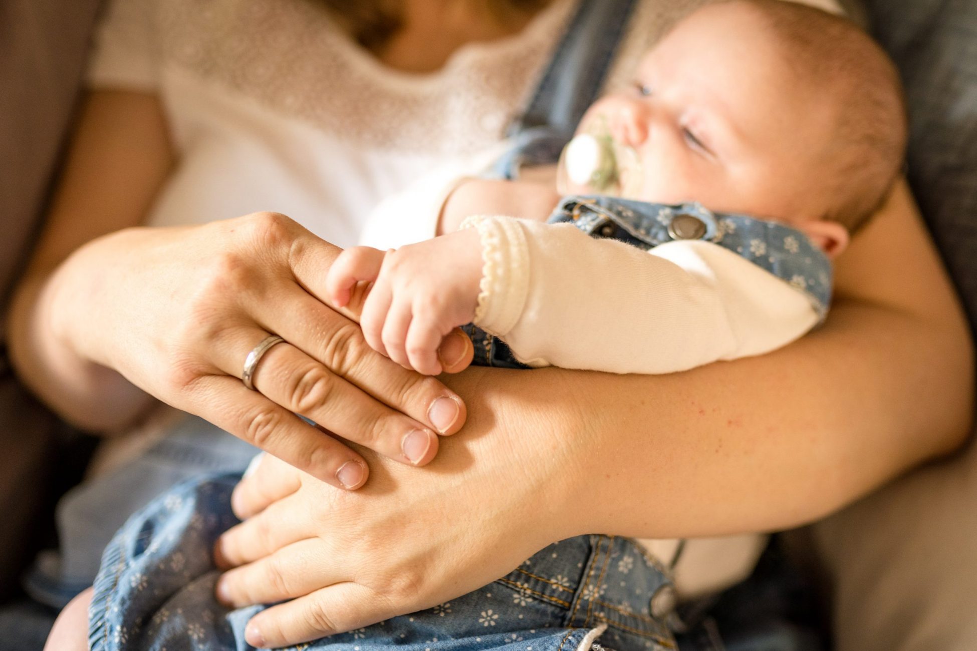 Baby liegt im Arm der Mama und entspannt sich und kuschelt