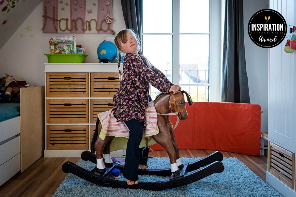 Familienreportage dokumentarsiche Fotografie Familienfotografie Kinderfotos Kind auf einem Schaukelpferd