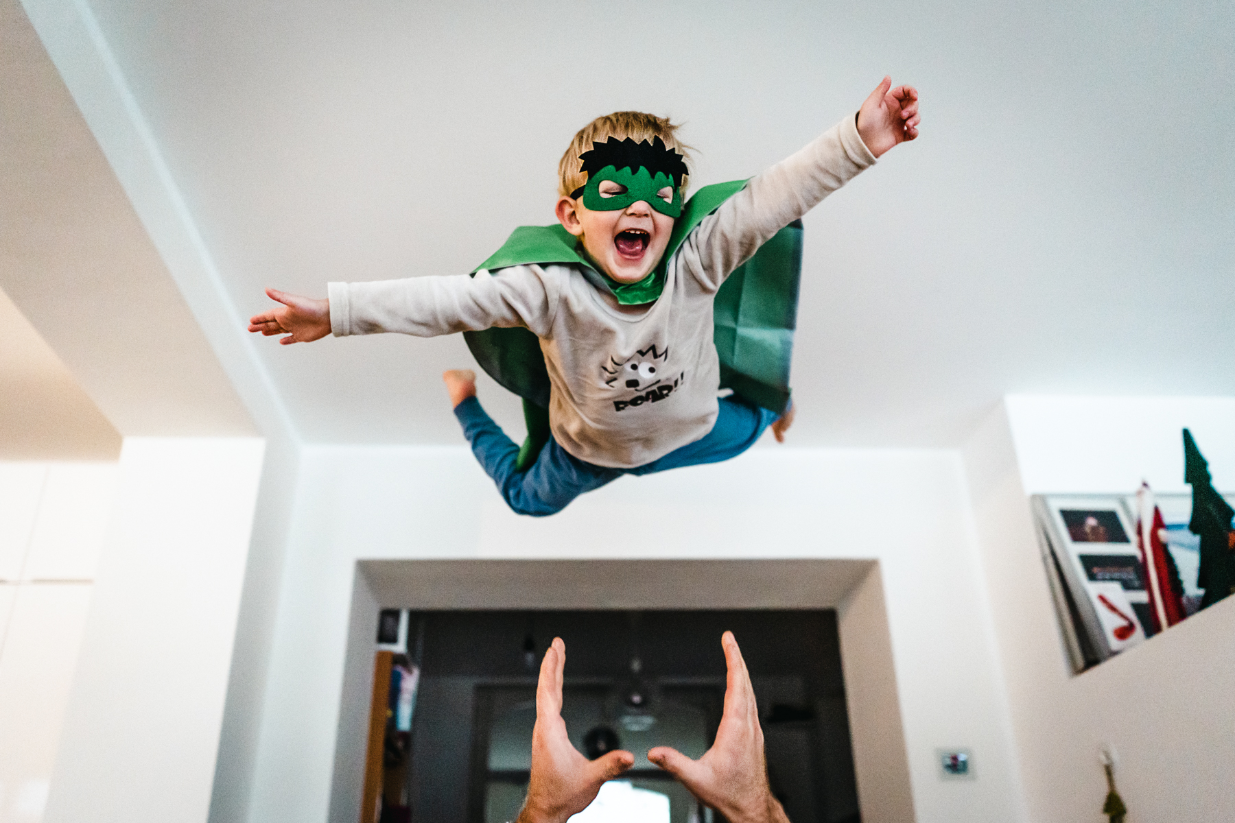 Kind im Superheldenkostüm fliegt durch die Luft